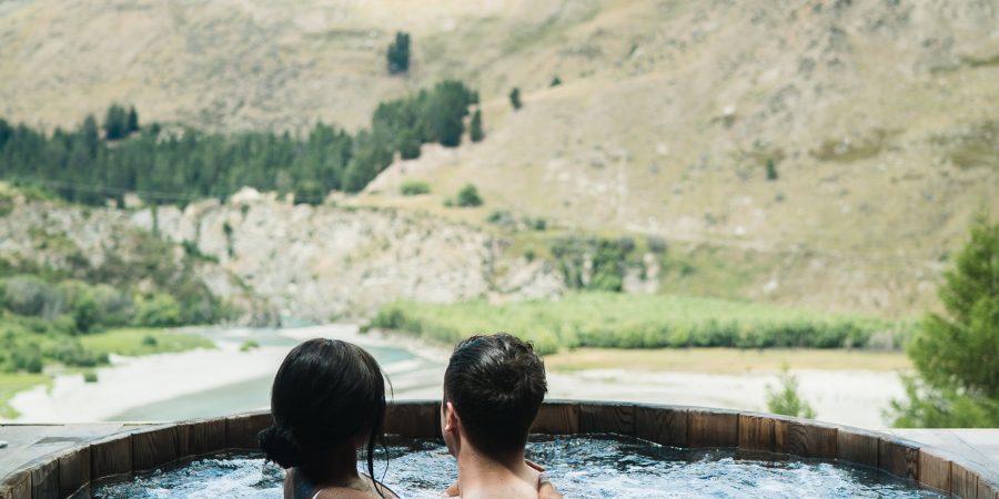 deux personnes dans un spa en bois face à la nature
